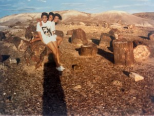 Three kids sitting on a petrified wood log.